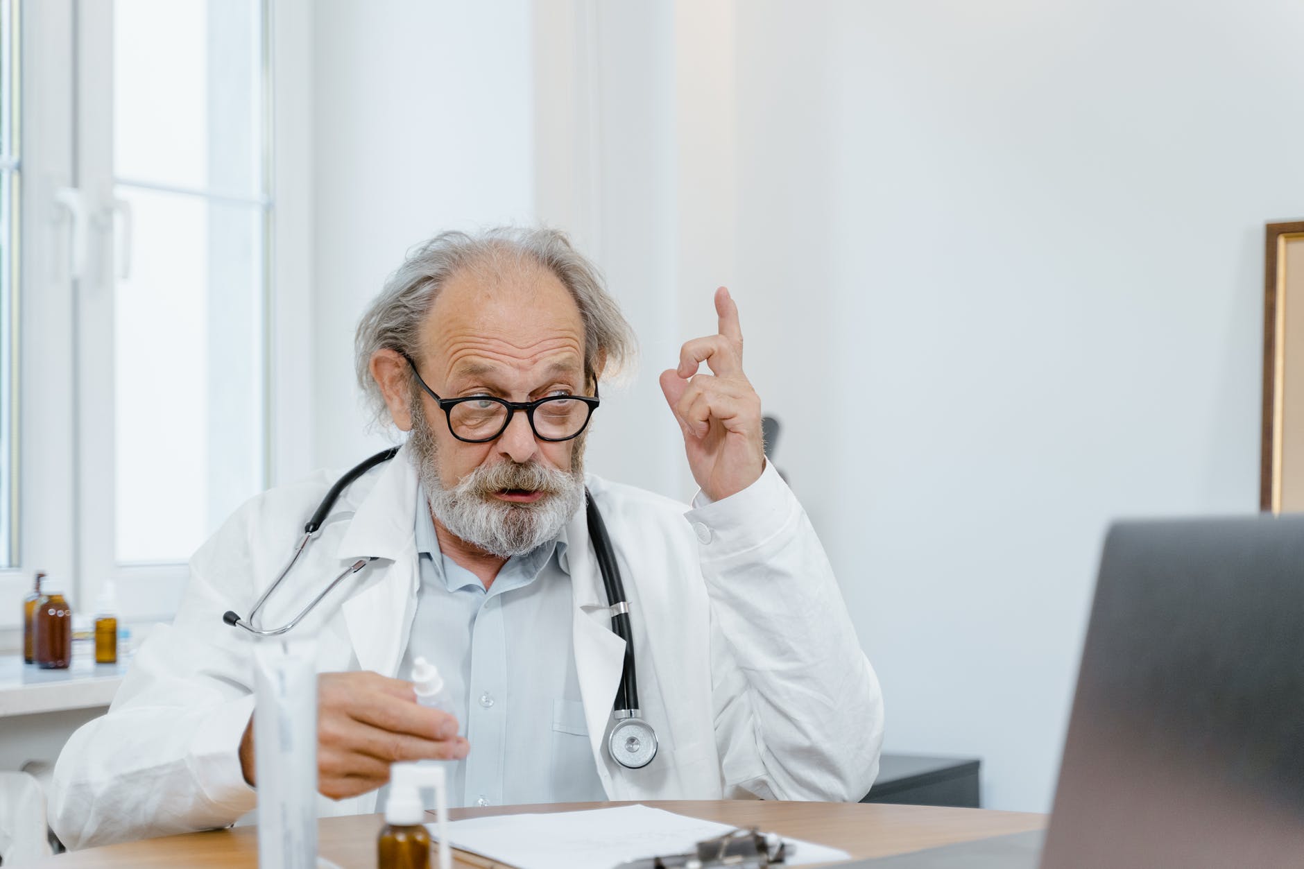 an elderly doctor giving online consultation